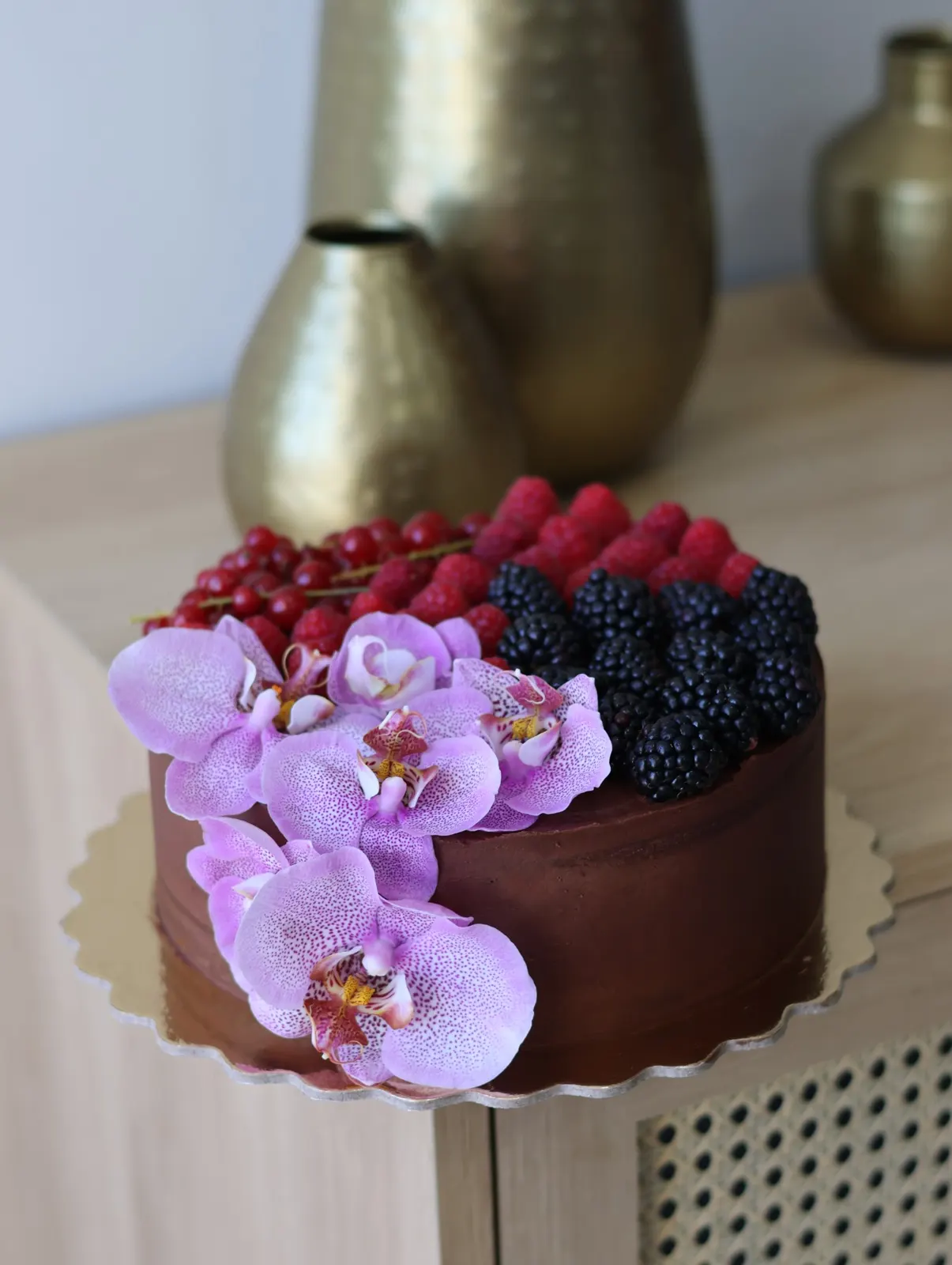 Bolo de chocolate com framboesas, amoras, groselhas e orquídeas