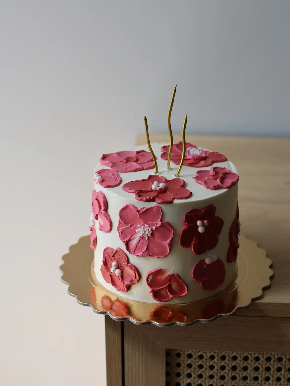 Bolo branco com flores cor-de-rosa pintadas à espátula